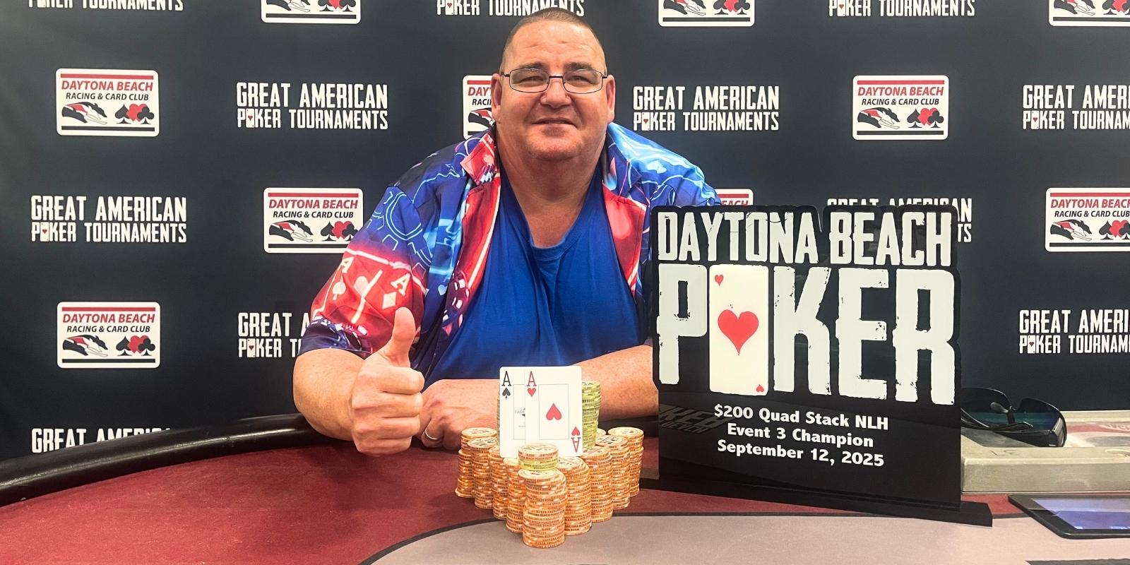 a person sitting at a poker table with a sign that says daytona beach poker