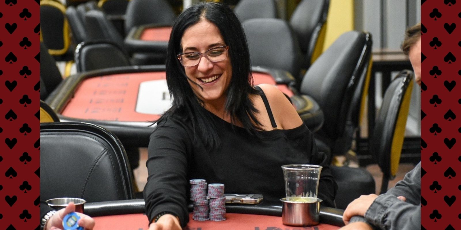 smiles while sitting at a poker table