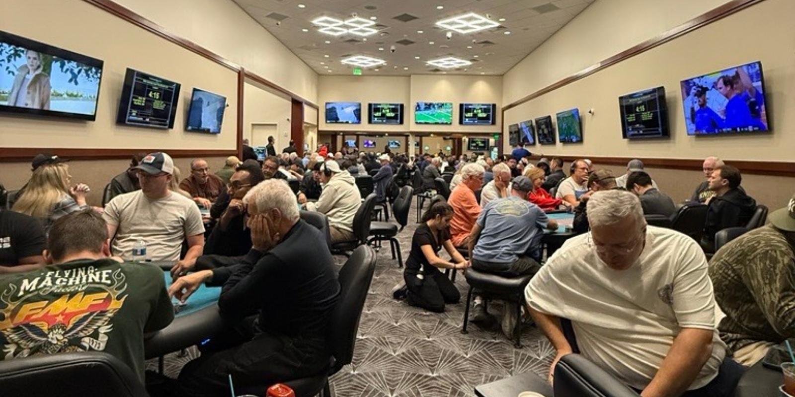 A large group of people sitting at tables in a poker room