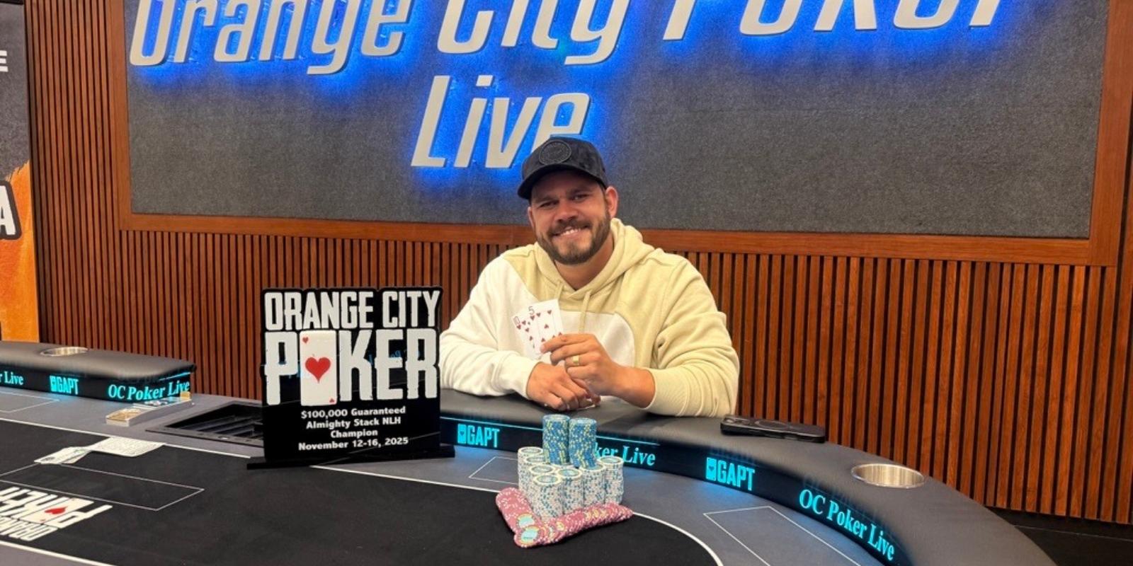 An orange city poker player poses for a photo in front of a poker table
