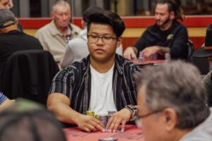 Poker player Kirk Chui waits for his turn to act prior to folding his hand.