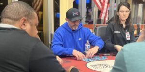 Eric Dillon stacks chips in a blue hooded sweatshirt and hat.