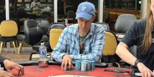 Steven Blay plays poker with blue plaid shirt and blue hat.