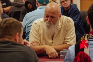 Moose sits at a poker table.