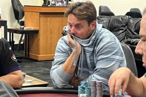 Chewing on his blue shirt Brian Schaedlich looks intently at his poker opponent.
